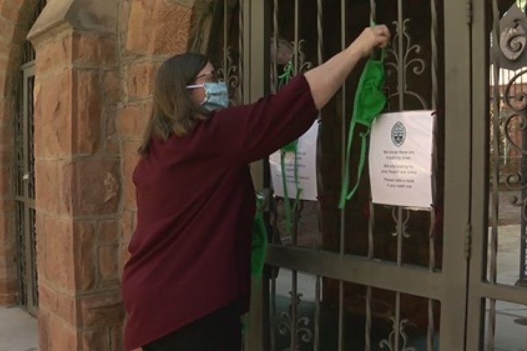 The Very Rev. Kristina Maulden hangs masks for the community