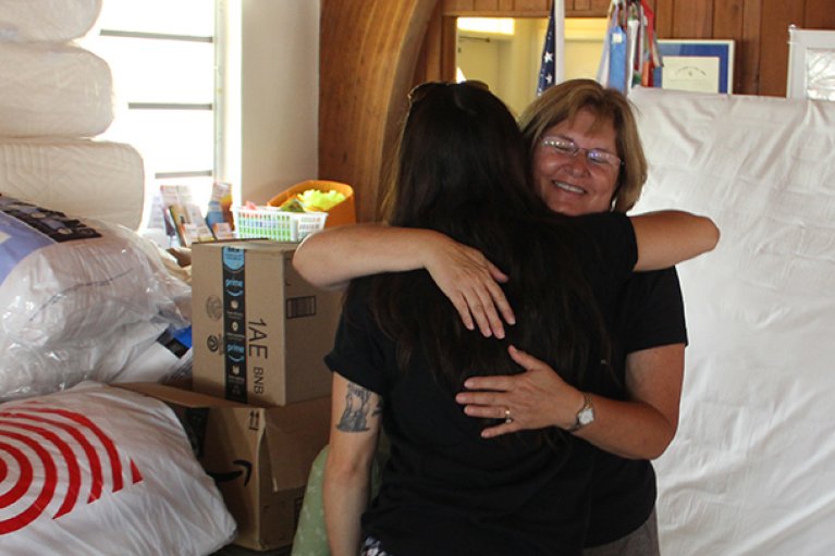 Rev. Debra of St. Columba is hugging a recipient of disaster support