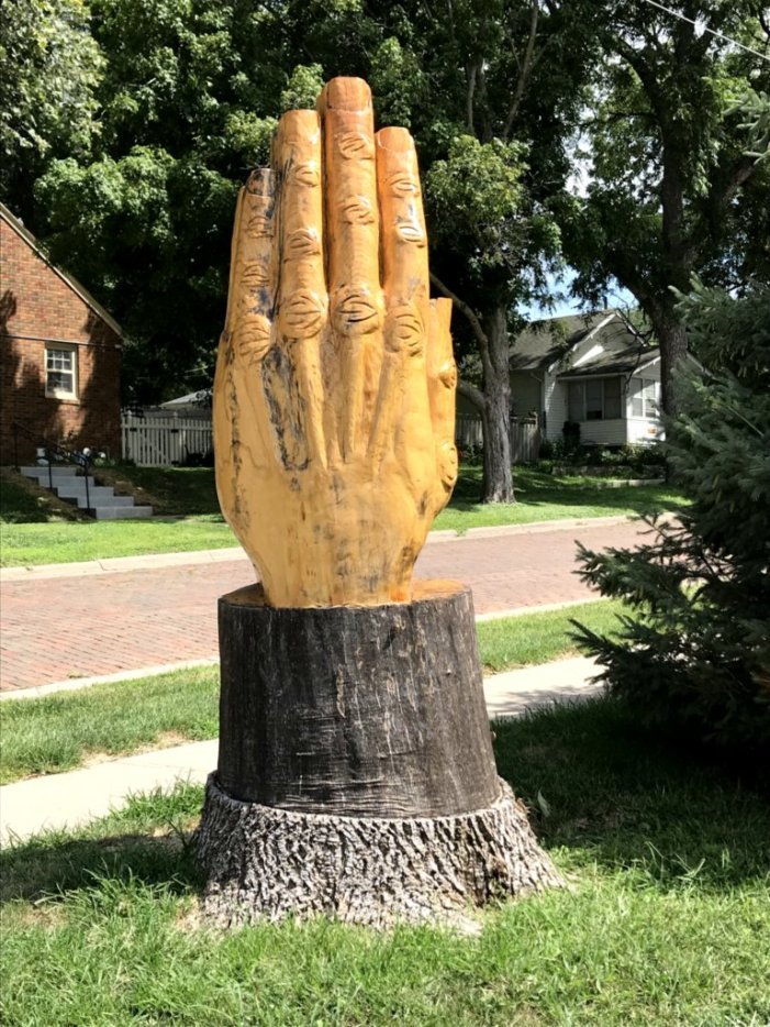 Praying hands sculpture created from storm damaged ash tree.